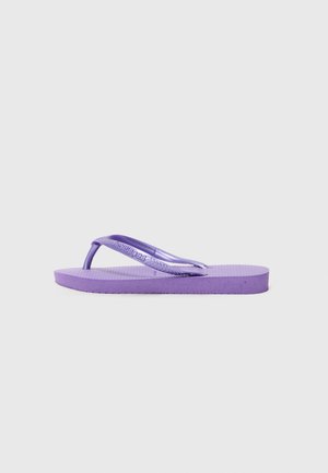 Flip-flop morado con suela texturizada, tiras finas y un sutil branding. Material ligero con una forma plana y redondeada.