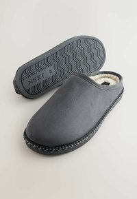 Szare kapcie wsuwane z miękką wyściółką wewnętrzną i textured czarną gumową podeszwą. Posiadają pleciony czarny akcent wokół podstawy.