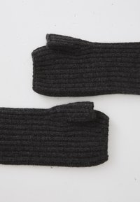 Ribbade, mörkgrå stickade strumpor med en tjock textur och förstärkta ankelområden, med en vikbar topp och släta kanter.