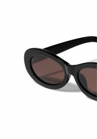 Black oval sunglasses with thick glossy frames and brown tinted lenses, featuring minimal hardware and a sleek, smooth texture.