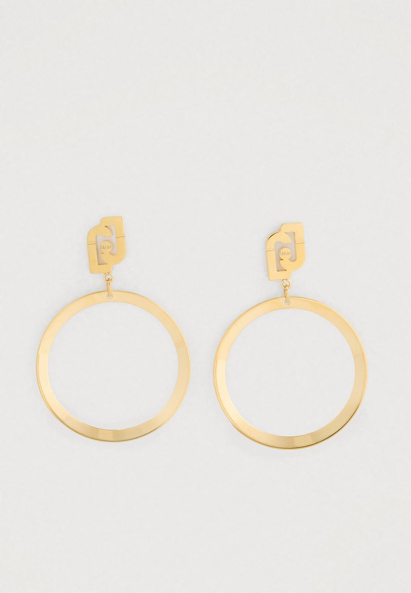 Et par guldfarvede hoop øreringe med geometriske stifter og minimalistisk åben cirkulær design på en hvid baggrund.
