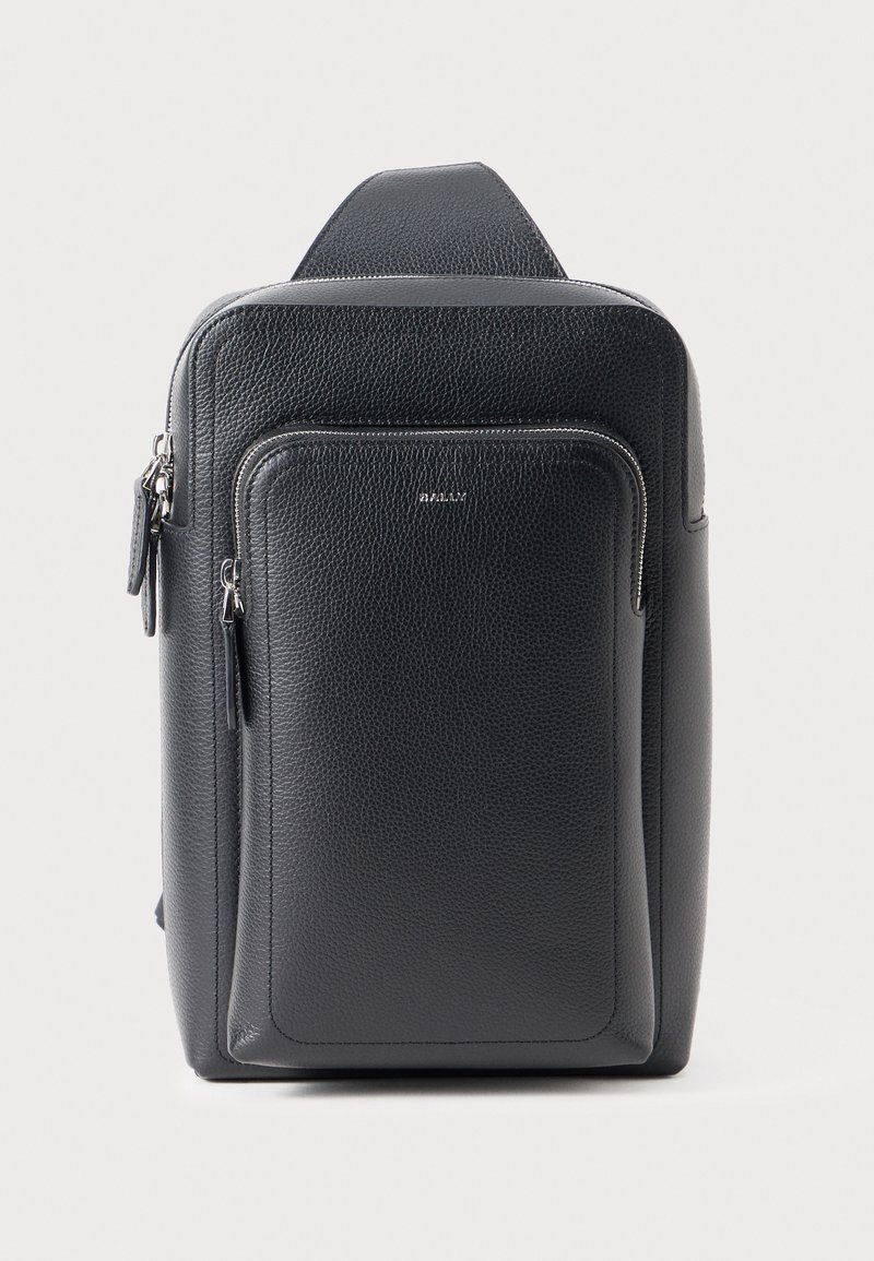 Μαύρο δερμάτινο σακίδιο πλάτης με υφή, ορθογώνιο σχήμα, μπροστινή τσέπη με φερμουάρ και ρυθμιζόμενο λουρί. Διακριτό λογότυπο στο μπροστινό μέρος.