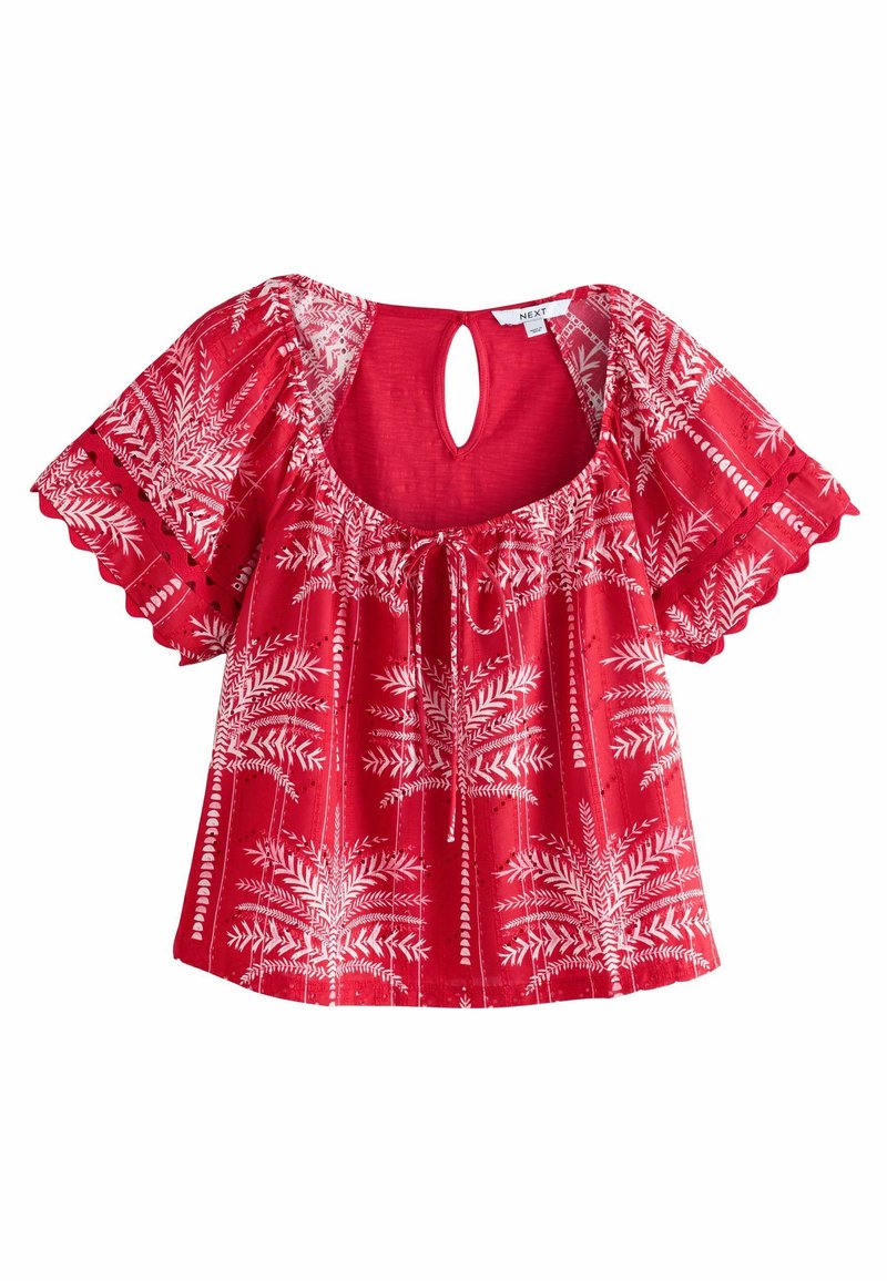 Blusa rossa con maniche corte a campana, caratterizzata da un motivo a foglie bianche, una schiena con apertura a forma di chiave e un davanti arricciato con un dettaglio a legaccio. Bordo ondulato.