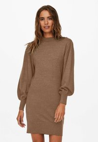 Robe pull en tricot marron avec un col montant, de longues manches bouffantes et une silhouette ajustée. Présente des poignets et un ourlet côtelés.