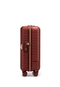 Hard-shell koffer in diep rood met ribbelstructuur, gouden rits, ingebouwd slot en vier wielen voor mobiliteit.