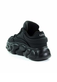 Czarny sneaker z wyprofilowaną, miękką podeszwą. Gładka syntetyczna cholewka, sznurowane zapięcie oraz wyściełana cholewka. Logo marki na pięcie.
