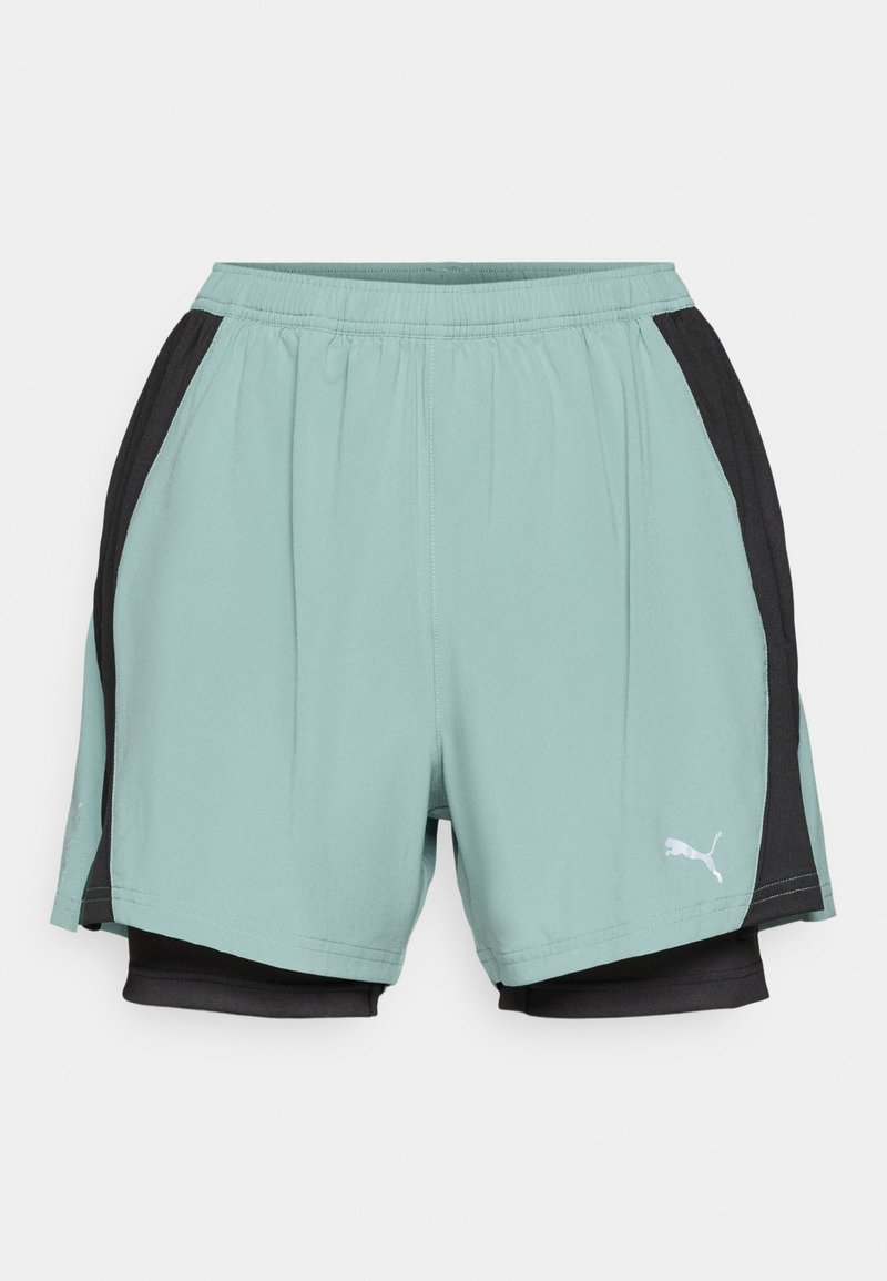 Pantalones cortos deportivos de color azul claro con paneles laterales negros, cinturilla elástica, tejido que absorbe la humedad y un pequeño logotipo blanco en la parte inferior izquierda.