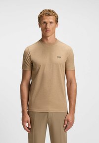 Hellbraunes Kurzarm-T-Shirt aus weichem Stoff, mit Rundhalsausschnitt und einem kleinen schwarzen "BOSS"-Logo auf der Brust.