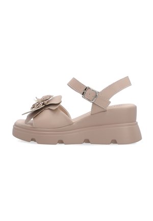 Beżowe sandały na koturnie z grubą podeszwą, paskiem na kostkę z klamrą oraz dużym ozdobnym kwiatem na przednim pasku.