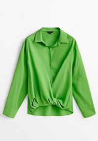 Chemisier vert vif à manches longues avec col, boutons et un nœud torsadé à l'avant au niveau de l'ourlet.