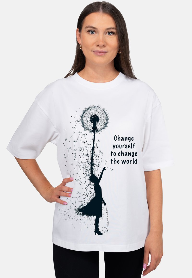 Witte katoenen T-shirt met een losse pasvorm. Voorzien van een zwarte silhouet van een meisje met een paardenbloem, vergezeld door de tekst: "Verander jezelf om de wereld te veranderen."