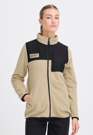 Fleecejacka i beige med svart övre panel. Har en dragkedjeficka, ståkrage och två sidofickor. Texturerat tyg.