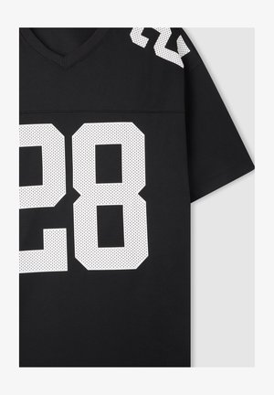 Czarna koszulka sportowa z dekoltem w kształcie V. Posiada duże białe siateczkowe numery "28" i "22" na ramionach, wykonana z przewiewnego materiału.