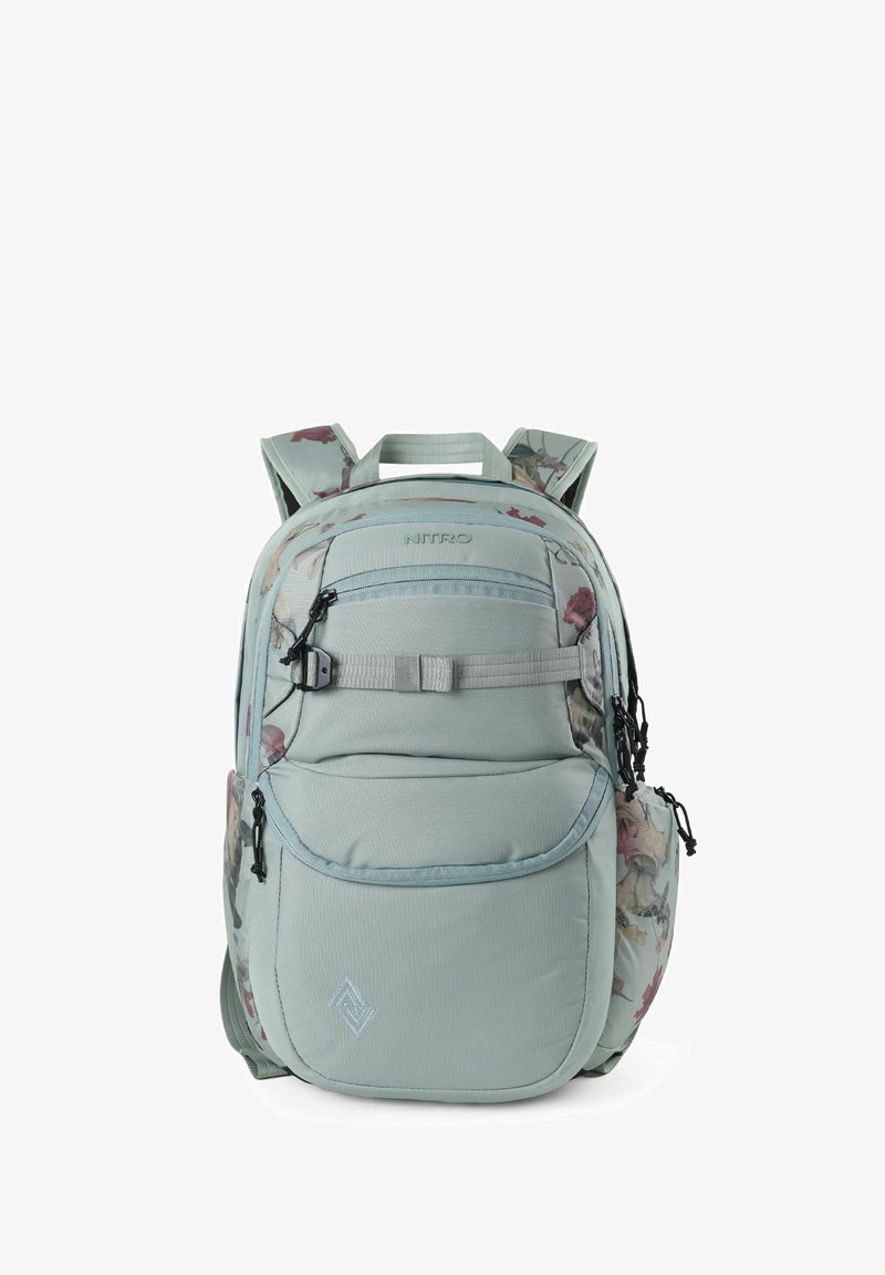 Mochila en un azul claro con patrón floral, múltiples compartimentos, costuras reforzadas, correas ajustables y un asa superior para llevar.