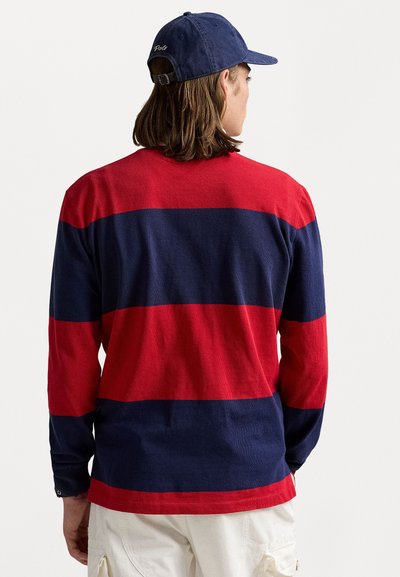 Chemise à manches longues avec des rayures horizontales rouges et marines, faite d'un tissu doux. Présente un col et des poignets côtelés, avec une coupe décontractée.