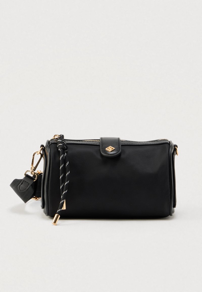 Μαύρη ορθογώνια τσάντα με λείο υλικό, χρυσά μεταλλικά στοιχεία, φερμουάρ και διακοσμητικό μαύρο-άσπρο λουράκι προσαρμοσμένο στο πλάι.