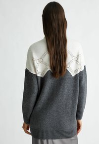 Maglione in maglia oversize con parte superiore grigia chiara e corpo grigio scuro, caratterizzato da un motivo geometrico nella parte superiore e polsini e orlo a costine.