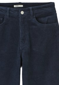 Pantalons en velours côtelé bleu marine avec une coupe évasée, dotés d'une fermeture frontale rivetée, de poches avant et d'une texture à côtes verticales.