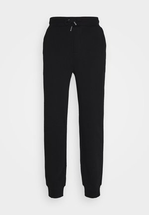 Sorte joggebukser laget av mykt stoff, med elastisk midjebånd med snor og tettsittende mansjetter ved anklene.