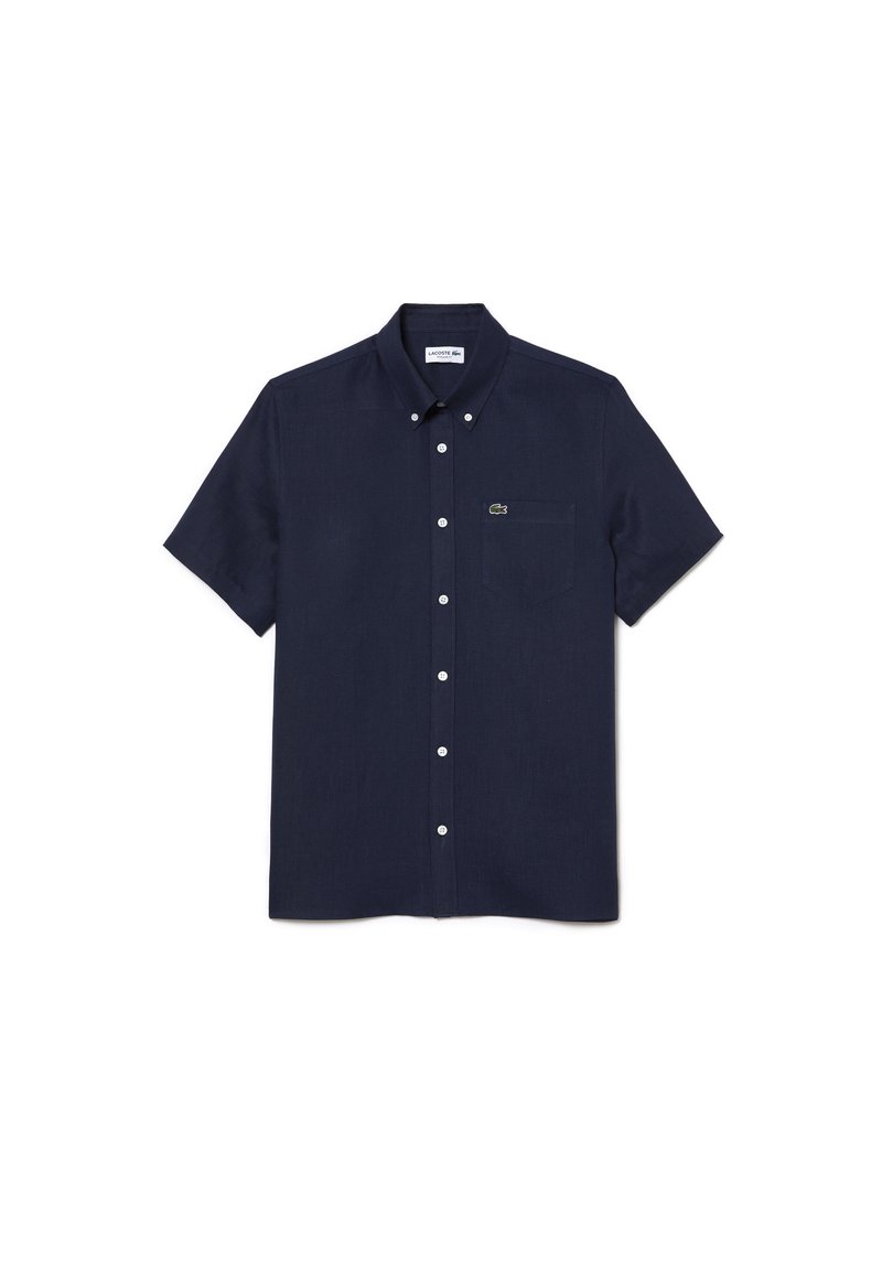 Camisa de botones de manga corta en color navy, hecha de tela texturizada, con un bolsillo en el pecho y un detalle del logo de Lacoste en el lado izquierdo.