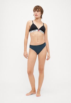 Czarny stanik w kształcie trójkąta z białą elastyczną taśmą z logo "TOMMY HILFIGER". Ciemnoniebieskie majtki bikini o prostym fasonie.