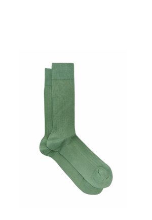 Een paar effen groene midkuitkousen met ribbelstructuur, plat gelegd op een witte achtergrond.