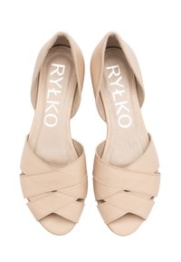 Beżowe skórzane buty na otwartym palcu z przekrzyżowanymi paskami, teksturowana wkładka oraz białe logo marki "RYŁKO" na wkładkach.