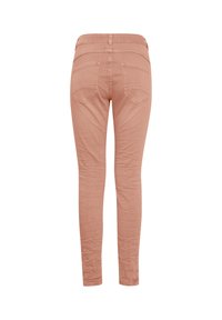 Jean skinny rose clair vu de dos, avec deux poches arrière et des détails de coutures, présenté sur fond blanc.
