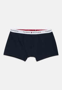 Marinblå bomullsboxershorts med en vit midjeresår med röda och blå detaljer och "TOMMY HILFIGER"-logotyp tryckt upprepade gånger.
