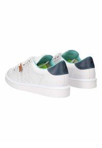 Zapatillas de cuero blancas con detalles perforados, forro interior verde y acentos azul marino en el talón. Suela de goma y diseño de punta redonda.
