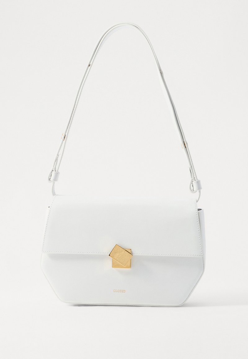 Valkoinen nahkainen olkalaukku, jossa on geometrinen kultaklipsi, tasainen muotoilu ja pitkänomainen hihna. Ominaisuuksina puhtaat linjat ja kiillotettu pinta.