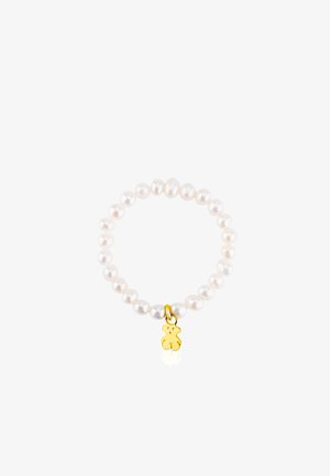 Weißes Perlenarmband mit einem goldenen Bärenanhänger. Es besteht aus runden, glatten Perlen und hat ein einfaches elastisches Design. Der Anhänger verleiht eine verspielte Note.