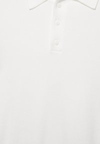 Bela polo majica s kratkimi rokavi, ovratnikom in štirimi belimi gumbi na sprednji preklopi.