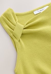 Light green sleeveless top made of ribbed knit fabric. Features a twisted detail at the shoulder and a simple, rounded neckline.