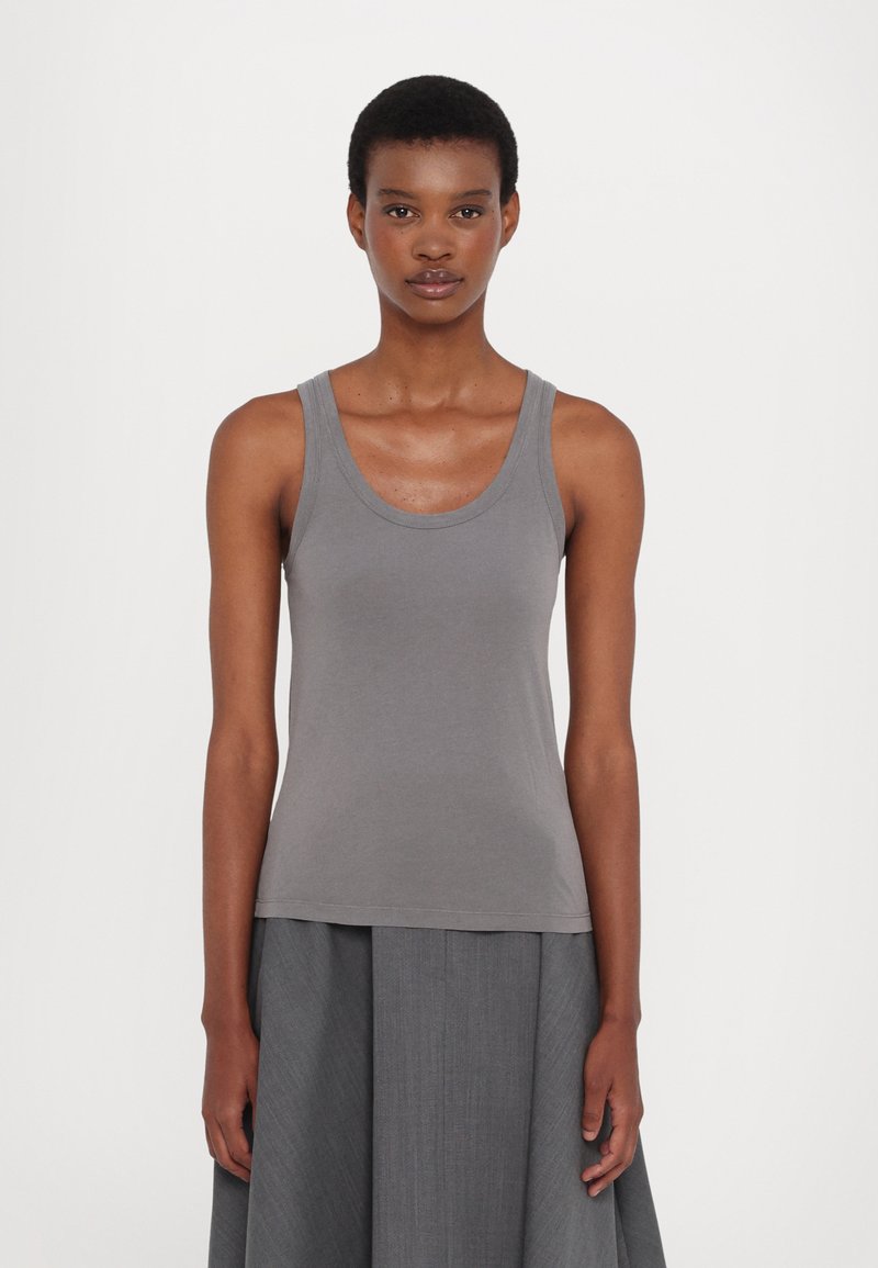Gray cotton tank top with a round neckline and wide straps, fitted at the torso, paired with a flowing gray skirt. Smooth texture.