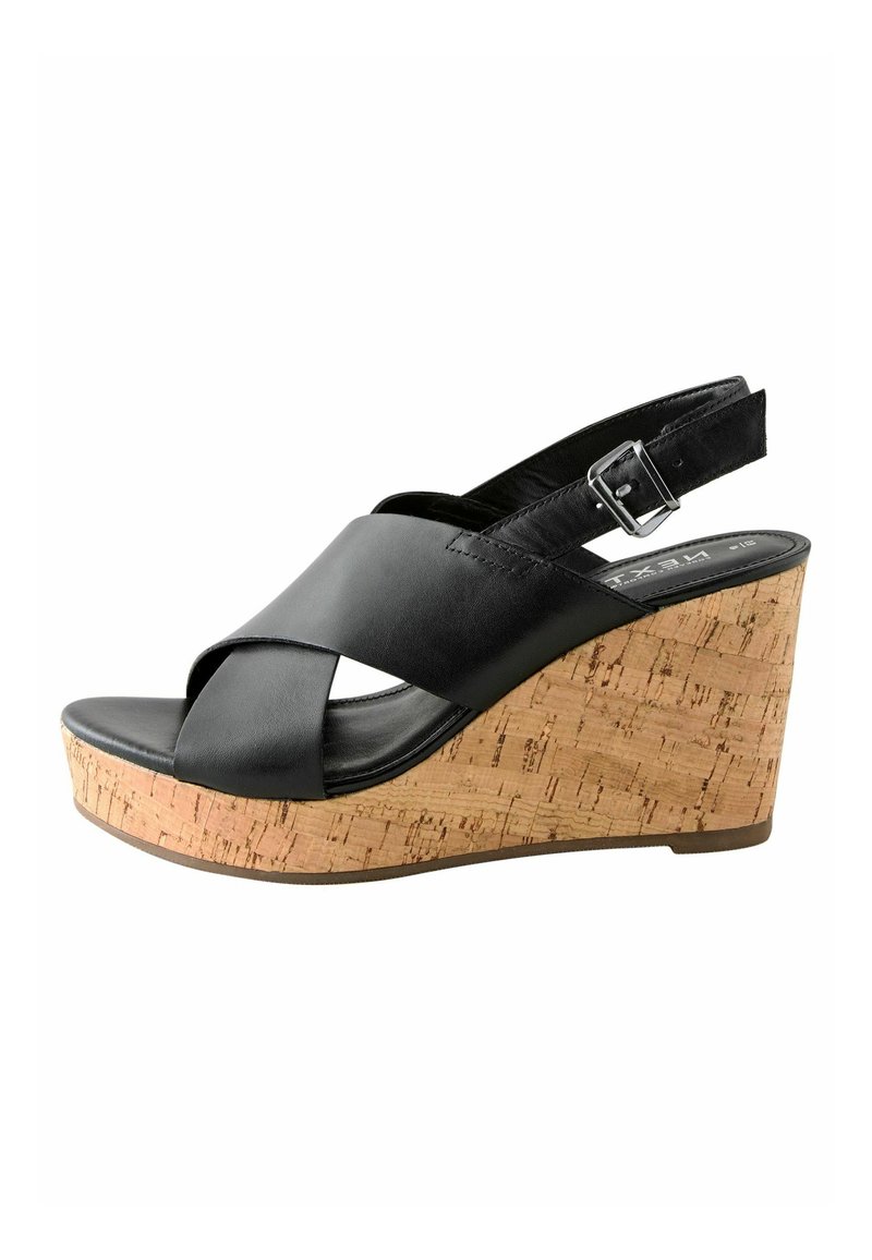 Black leather wedge sandal with cross-strapped design. Cork platform adds texture and height. Adjustable ankle strap with buckle detail.