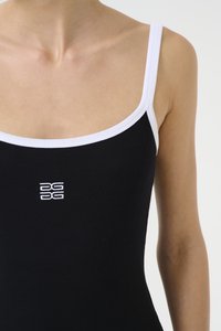 Juodas briaunotas maikė su baltais kontrastingais dirželiais. Centriniuose krūtinės vietoje yra mažas baltas logotipas. Minkšta tekstūra ir prigludęs dizainas.