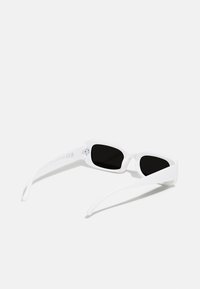 Lunettes de soleil blanches avec des verres foncés, dotées d'une monture rectangulaire et d'une finition lisse et brillante. Branches étroites avec un détail de marque subtil.