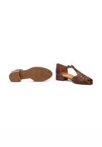 Sandalias de cuero marrón con un diseño de tira en T, punta abierta y detalles trenzados. Tacón bajo y suela de goma texturizada.