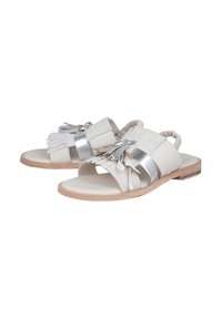 Sandalo bianco in pelle con accenti metallici argento, con frange decorative, punta aperta e suola piatta beige.