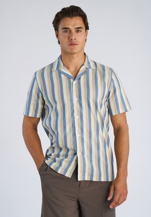 Koszula z krótkim rękawem w pionowe paski w kolorze jasnoniebieskim, beżowym i ciemnoniebieskim. Posiada zapięcie na guziki z przodu oraz luźny kołnierz.
