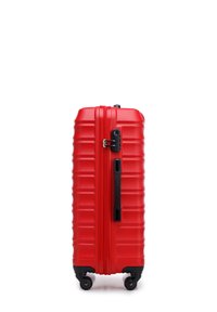 Valigia rigida rossa con texture a righe, manico nero e ruote. Dotata di una cerniera e di un lucchetto a combinazione per la sicurezza.