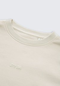 Crème-kleurige sweatshirt met een geribde kraag en subtiele, geborduurde "ITS OK" logo op de voorkant. Zachte stof en een ontspannen pasvorm ontwerp.