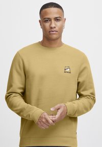 Yellow cotton sweatshirt with ribbed cuffs, crew neck, and a small embroidered design featuring a duck. Smooth texture, regular fit.