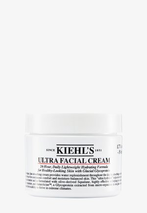 Rund hvid krukke med et hvidt låg, mærket "Kiehl's Ultra Facial Cream," med sort tekst der beskriver produktfordele og ingredienser.
