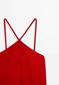 Haut rouge sans manches avec fines bretelles doubles spaghetti croisées dans le dos sur fond blanc.