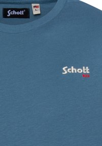 T-shirt bleu à manches courtes avec col côtelé ; présente un logo brodé blanc "Schott" et "N.Y.C." en rouge ; fabriqué dans un tissu lisse et léger.
