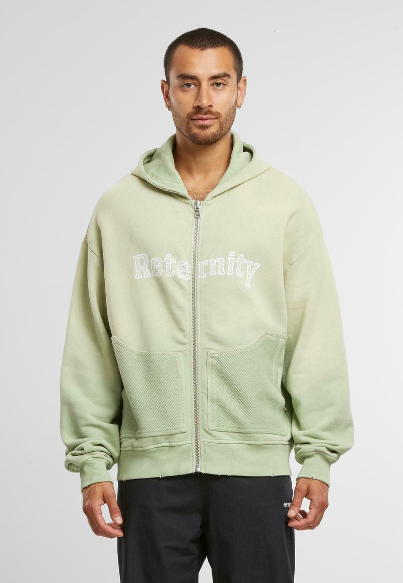 Hoodie zippé vert à coupe décontractée, avec deux poches avant, une section inférieure texturée et le logo "Reternity" en blanc.