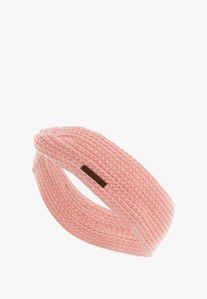 Gebreide haarband in een zachte perzikkleur, met een gedraaid ontwerp en een gestructureerd patroon, voorzien van een klein bruin leren labelaccent.