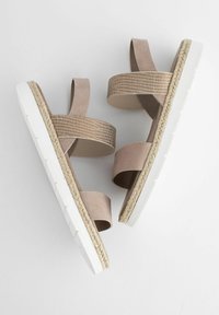 Heledad pruunid sandaalid, millel on kaks laia rihma, tekstureeritud bänd ja valge platvormeine, mille ääres on espadrille detail.